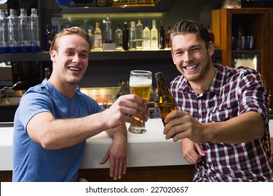 Young Men Drinking Beer Together At The Bar