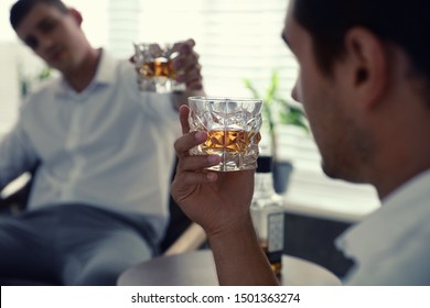 Young Men Drinking Whiskey Together At Home