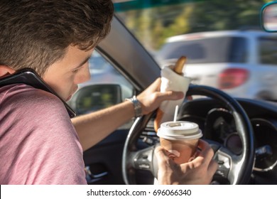 Young Men Driving Car And Eating Coffee, Talking On Phone And Holding A Hot Dog