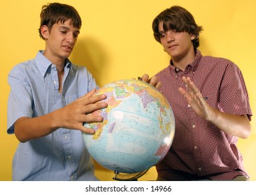 young men looking at globe