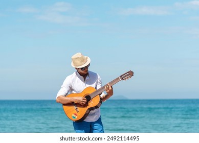 Young men playing acoustic guitar on the beach. Happy man person playing acoustic guitar music instrument seaside sitting on sand tropical beach island. Asian musician Happy guitarist hobby lifestyle - Powered by Shutterstock