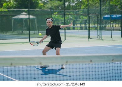 Young men playing tennis at sunny day on a tennis outdoors court. A men play tennis having fun. Sport activity and tennis training concept. - Powered by Shutterstock