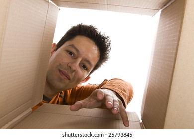 Young Men Reaching Something Inside A Cardboard Box