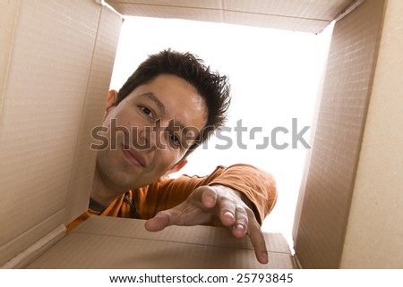 young men reaching something inside a cardboard box