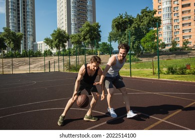 Young men training while playing basketball on playground
