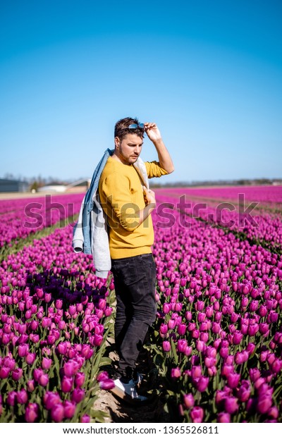 young men in tulip field in the\
Netherlands, man in pink flower field during\
spring