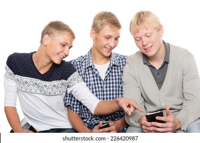 Young men use smartphones and sitting on the couch. Two of the boys twin brothers.