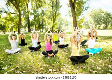 Young Men And Women Doing Yoga Outdoor