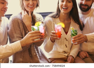 Young men and women drinking cocktail at party