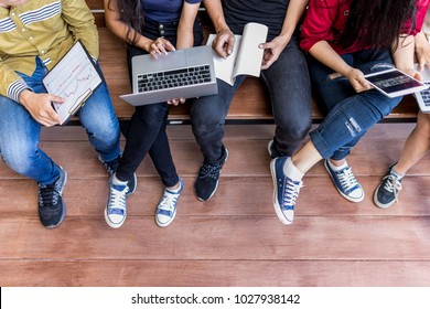 Young Men And Women Sitting Relaxed Use Tablet ,computer Notebook On A Wooden Bench In College.Students Using Technology To Learn The Lessons Of The Student Group During Semester.summer School Camp