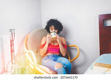 Young Mexican Woman Drinking Cup Of Coffee, Sitting In Room