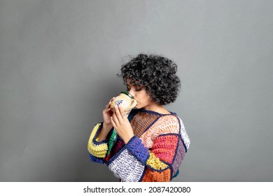 Young Mexican Woman With Sweater Drinking Coffee From Traditional Cup