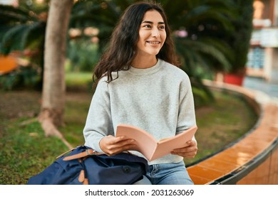 Young Middle East Student Girl Smiling Happy Reading Book At The City