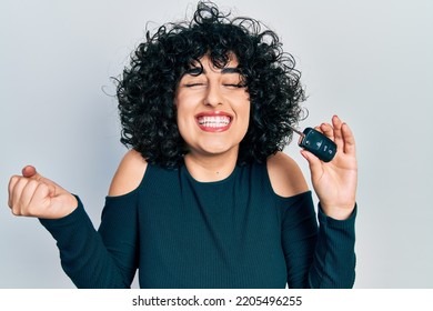 Young Middle East Woman Holding Key Of New Car Screaming Proud, Celebrating Victory And Success Very Excited With Raised Arm 