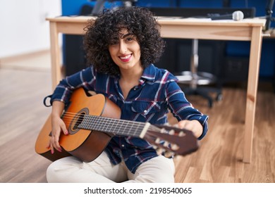 Young middle east woman musician playing classical guitar at music studio