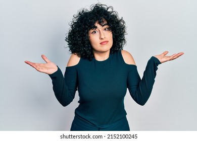 Young Middle East Woman Wearing Casual Clothes Clueless And Confused With Open Arms, No Idea And Doubtful Face. 