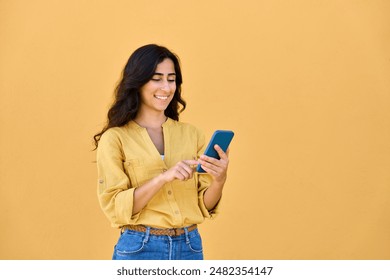 Young middle eastern brunette woman in casual clothes using mobile cellphone app for communication, shopping, buying, trading online. Smiling arabian girl holding smartphone phone, scrolling, typing - Powered by Shutterstock