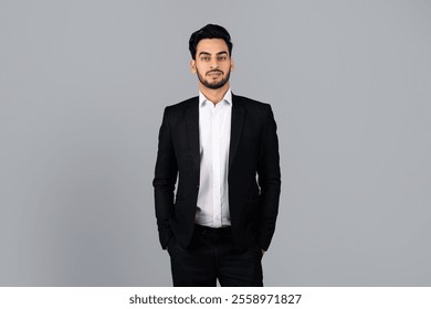 A young Middle Eastern businessman stands confidently in a studio setting. His formal attire and demeanor reflect his entrepreneurial spirit and professionalism in a corporate environment. - Powered by Shutterstock