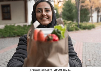 Young middle eastern female volunteer delivering meals. Grocery delivery service - Powered by Shutterstock