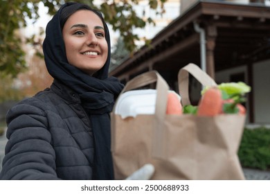 Young middle eastern female volunteer delivering meals. Grocery delivery service - Powered by Shutterstock