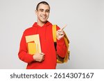 Young middle eastern man boy student wear red casual clothes backpack bag hold books point index finger aside on area isolated on plain solid white background. High school university college concept