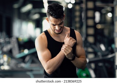 Young Middle Eastern Man Having Wrist Pain, Suffering Sport Trauma After Training At Gym, Injured Arab Male Athlete After Fitness Workout Rubbing Painful Area And Frowning, Closeup Shot, Free Space - Powered by Shutterstock