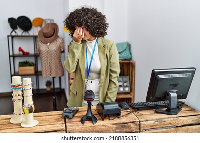 Young middle eastern woman working as manager at retail boutique tired rubbing nose and eyes feeling fatigue and headache. stress and frustration concept. 