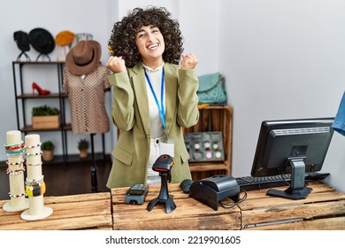 Young Middle Eastern Woman Working As Manager At Retail Boutique Celebrating Surprised And Amazed For Success With Arms Raised And Open Eyes. Winner Concept. 