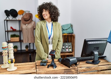 Young Middle Eastern Woman Working As Manager At Retail Boutique Smiling Looking To The Side And Staring Away Thinking. 