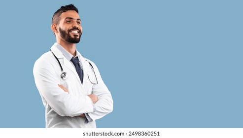 Young Middle-Eastern Doctor Man Crossing Hands Smiling Looking Aside At Blank Space For Your Text In Studio Over Blue Background. Medical Advertisement With Healthcare Professional. Panorama - Powered by Shutterstock