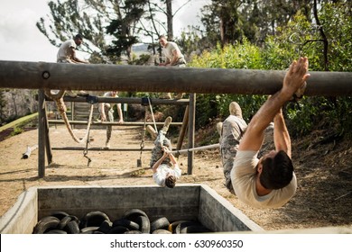 Young military soldiers practicing rope climbing during obstacle course at boot camp - Powered by Shutterstock