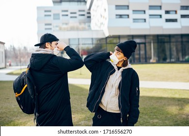 Young Millenial Couple Touching Each Other Elbow To Protect While Pandemic Of Covid19, Socail Distancing While Coronavirus With People On The Street In Casual Clothes