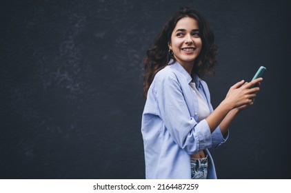 Young millennial woman texting message on smartphone app. Female chatting in social network on copy space background. Influencer reading notification on mobile phone. Online payment and web browsing