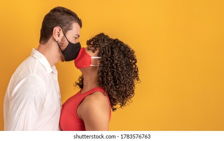 Young Millennials Couple Wearing Protective Face Masks And Kissing Each Other, Virus Spread Prevention And People Concept. Valentine Couple With Mask. Quarantine
