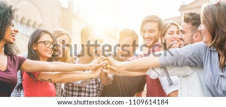 Young millennials friends stacking hands together - Happy students celebrating together - Youth lifestyle, university, relationship and friendship concept - Focus on hands