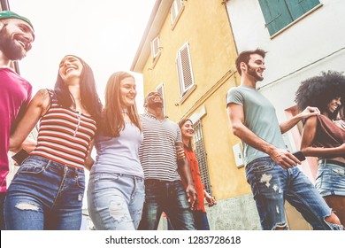 Young millennials friends walking in city old town center - Happy people having fun together - Youth lifestyle, generation z and friendship concept - Main focus on black man and blond girl faces - Shutterstock ID 1283728618