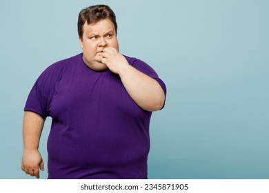 Young minded pensive sad chubby overweight man wears purple t-shirt casual clothes bititng nails fingers looking aside on area isolated on plain pastel light blue cyan background. Lifestyle concept - Shutterstock ID 2345871905