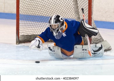 Young Minor Ice Hockey Goaltender Making A Save During A Game