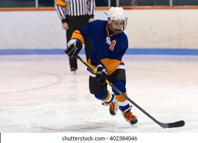 Young Minor Ice Hockey Player Skating During A Game In An Arena