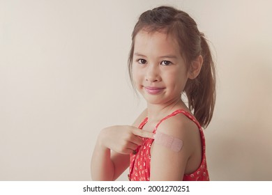 Young Mixed Asian Girl Showing Her Arm With Bandage After Got Vaccinated Or Inoculation, Child Under 12 Years Old Immunization, Health Concept, Covid Delta Vaccine