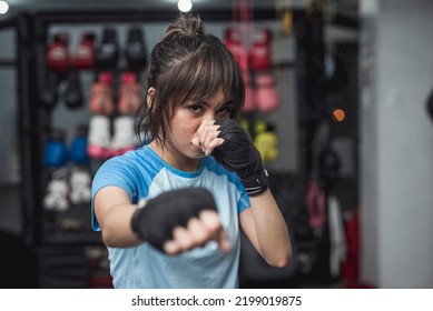 A young mixed martial arts athlete fiercely poses for the camera while demonstrating the proper fighting stance in throwing a punch. - Powered by Shutterstock