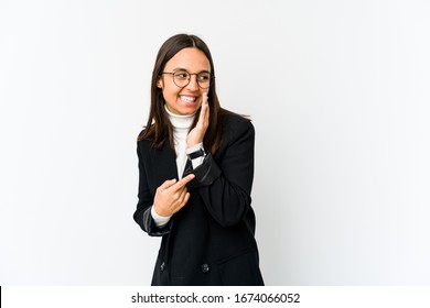 Young mixed race business woman isolated on white background saying a gossip, pointing to side reporting something.