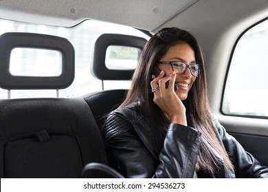 Young Mixed Race Businesswoman Portrait Inside A Taxi In Canary Wharf Area In London Talking At The Phone.