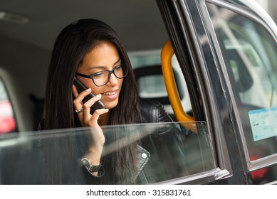 Young Mixed Race Businesswoman Portrait Inside A Taxi In Canary Wharf Area In London Talking At The Phone.