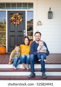 Young Mixed Race Chinese And Caucasian Family Portrait On Their Front Porch.