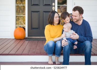 Young Mixed Race Chinese And Caucasian Family Portrait On Their Front Porch.