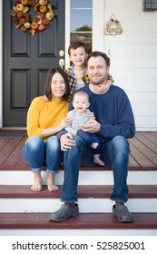 Young Mixed Race Chinese And Caucasian Family Portrait On Their Front Porch.