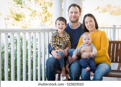 Young Mixed Race Chinese And Caucasian Family Portrait On Their Front Porch.