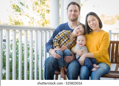 Young Mixed Race Chinese And Caucasian Family Portrait On Their Front Porch.