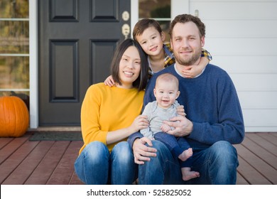 Young Mixed Race Chinese And Caucasian Family Portrait On Their Front Porch.